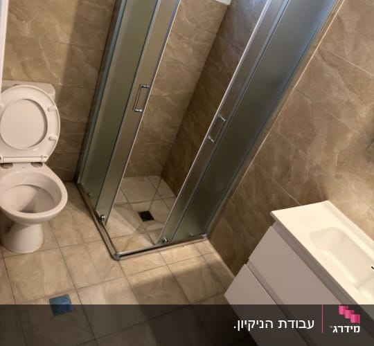 חדר אמבטיה עם מקלחון, כיור ואסלה